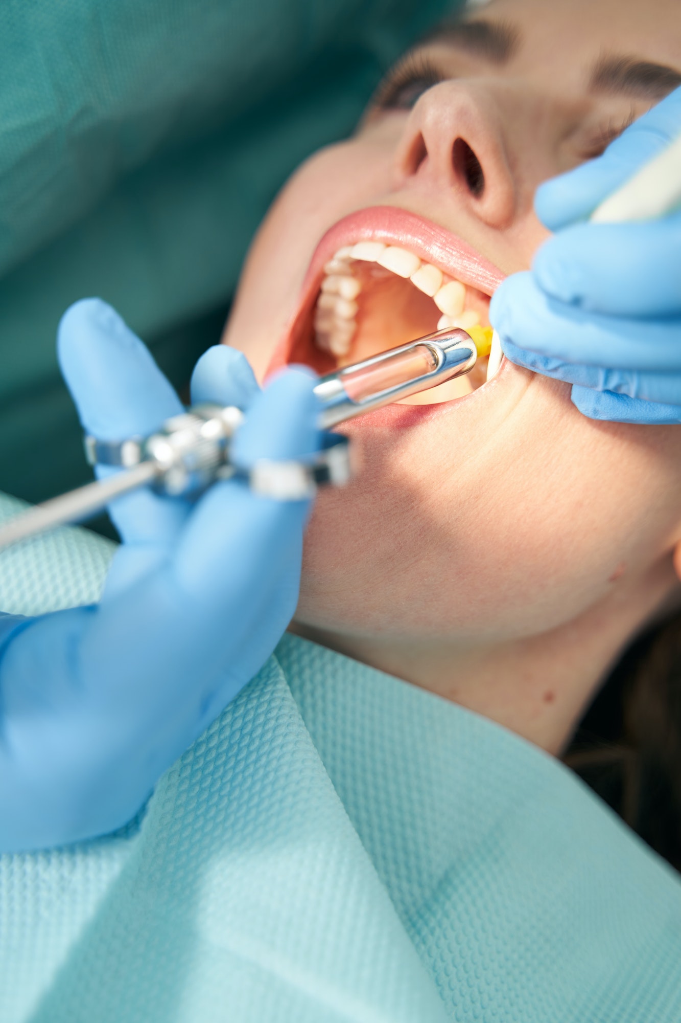Dentist injecting anesthetic medicine into patient inner cheek